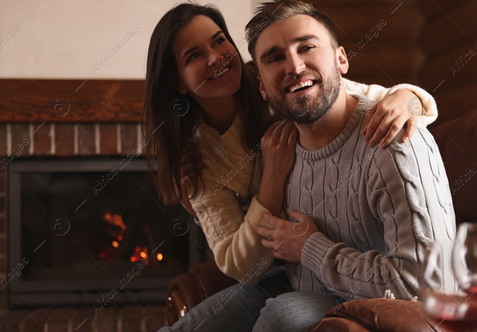 Photo of Lovely couple resting near fireplace at home. Winter vacation