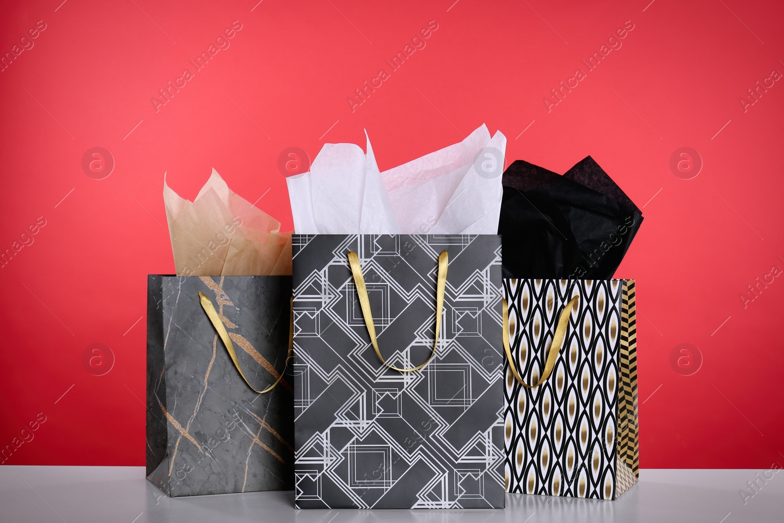 Photo of Shopping bags with paper on red background