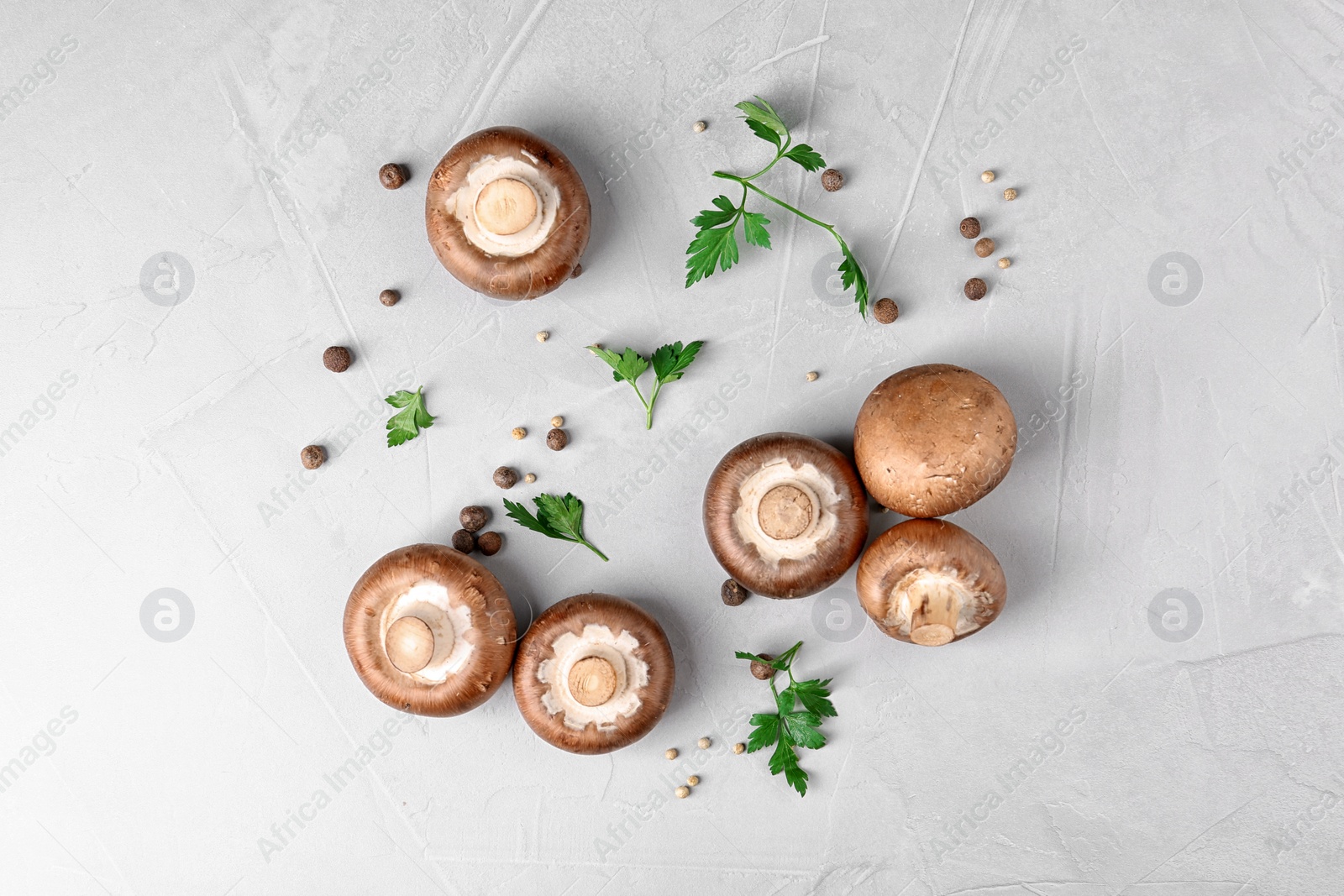 Photo of Flat lay composition with fresh champignon mushrooms on grey background