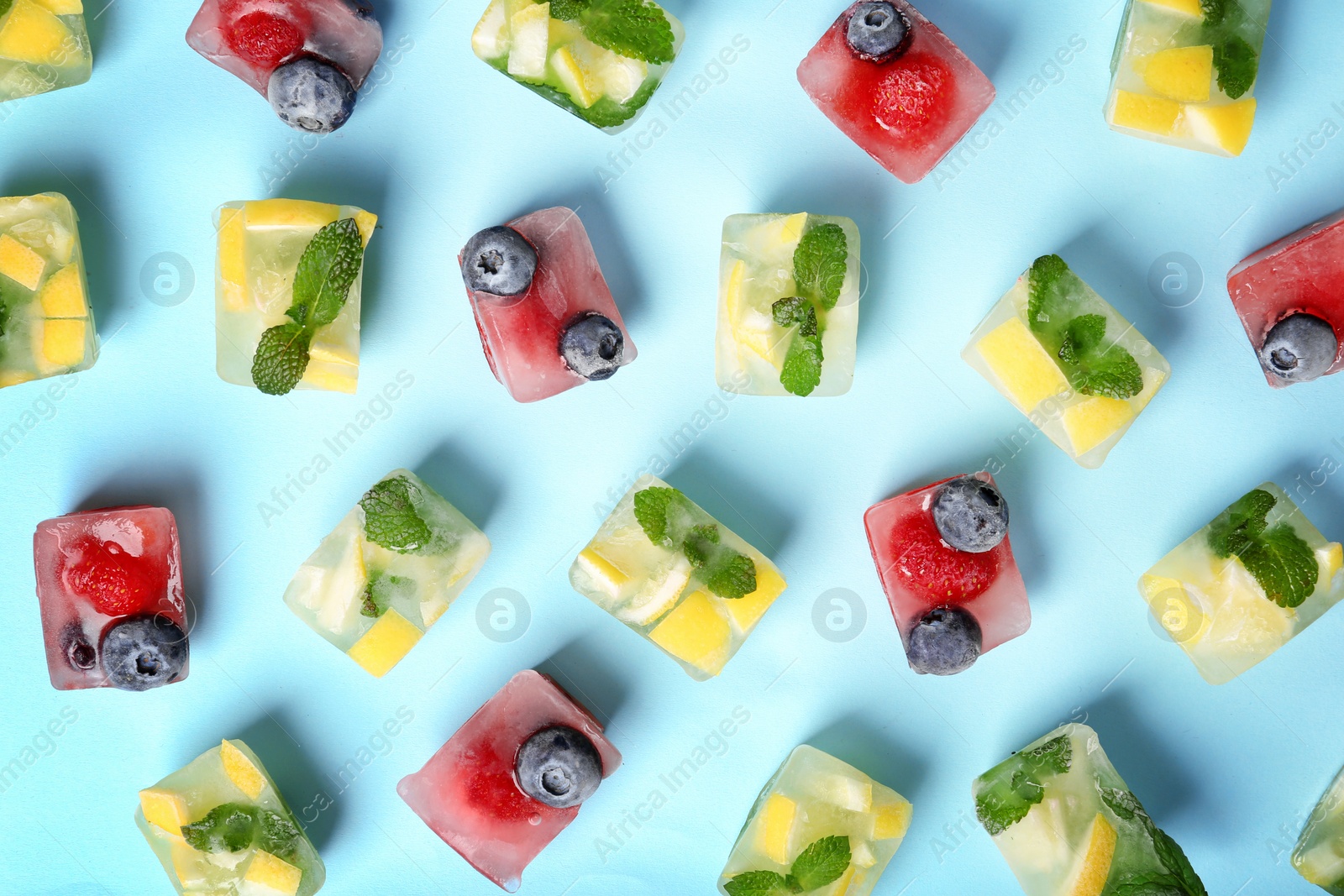 Photo of Flat lay composition with fruit and berry ice cubes on color background