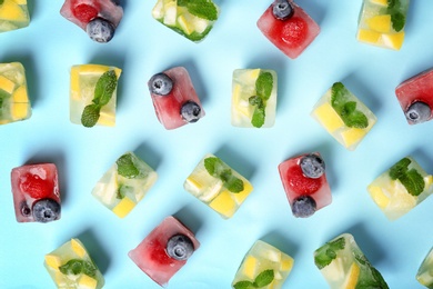 Flat lay composition with fruit and berry ice cubes on color background