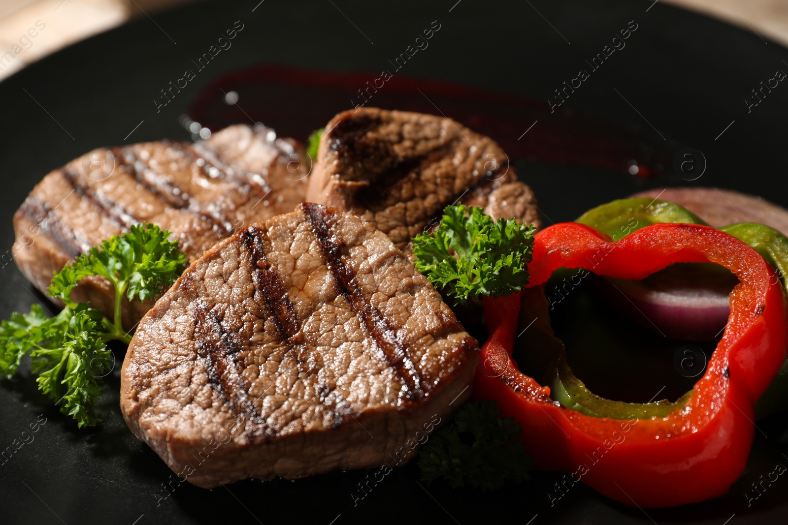 Photo of Grilled meat served with garnish on plate, closeup