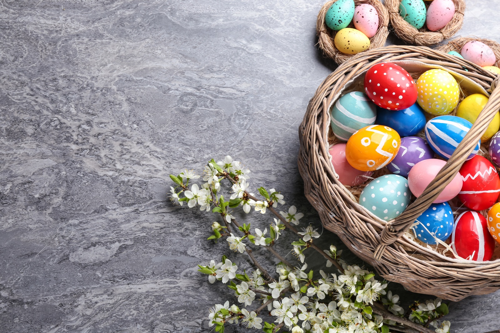 Photo of Flat lay composition with painted Easter eggs and blossoming branches on color background. Space for text