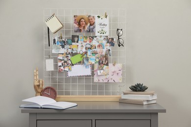 Photo of Chest of drawers with vision board and decor elements near grey wall indoors