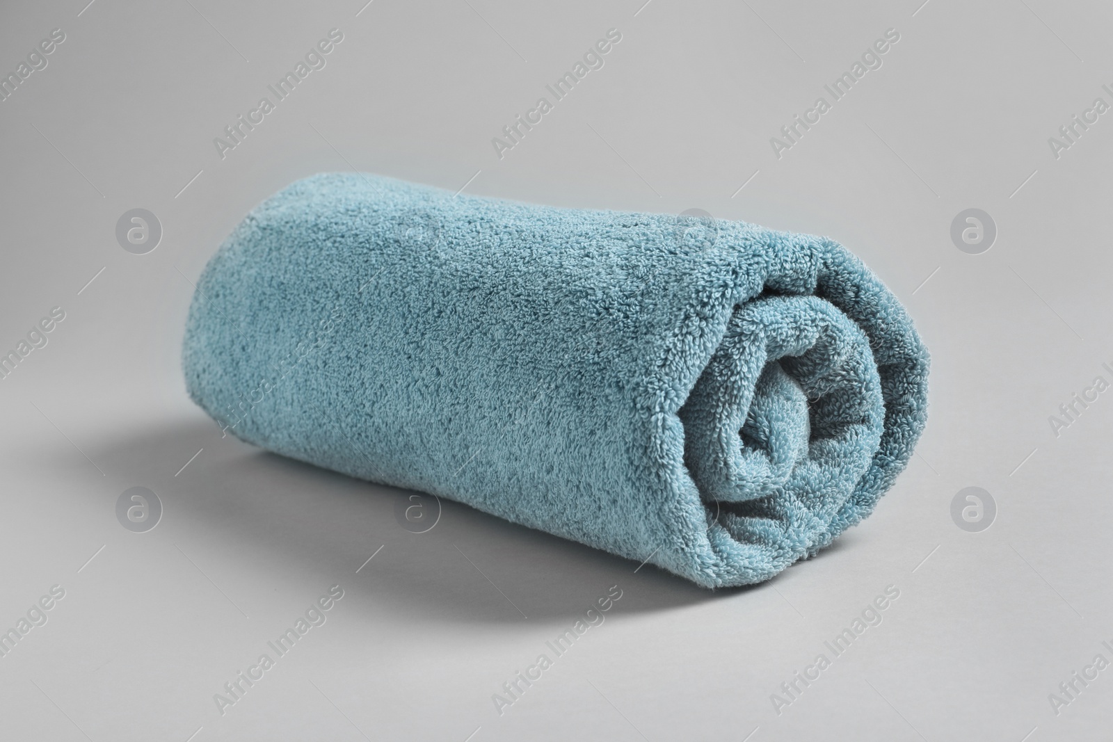 Photo of Fresh soft rolled towel on light background