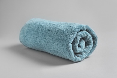 Photo of Fresh soft rolled towel on light background