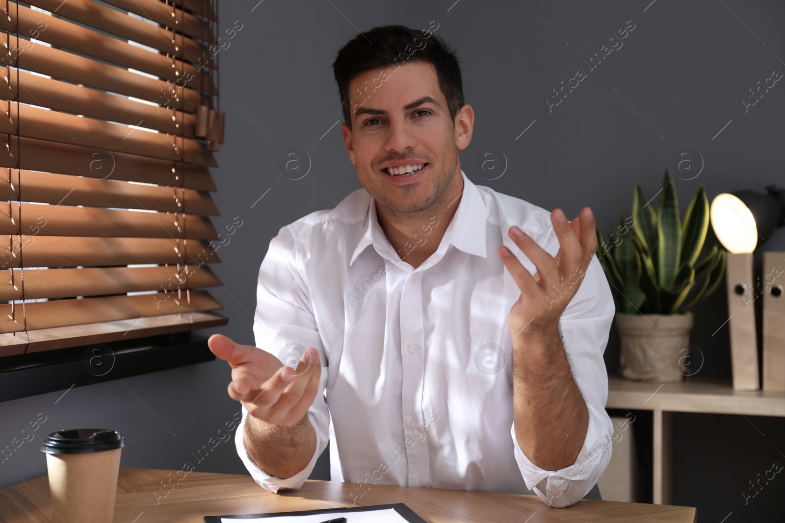 Photo of Man talking to his coworkers through video conference indoors, view from webcam