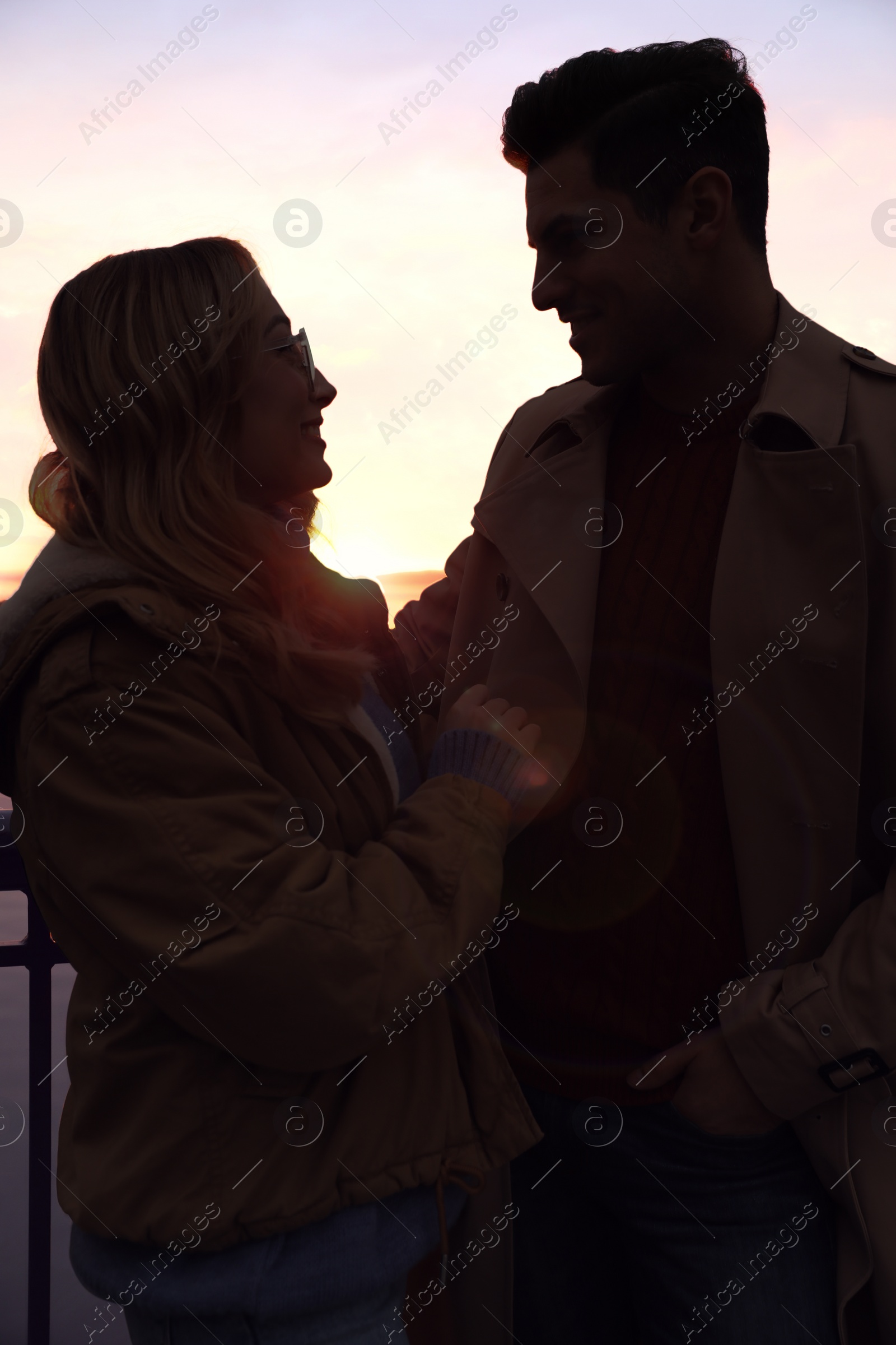 Image of Silhouette of lovely couple looking at each other at sunset
