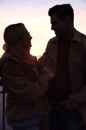 Image of Silhouette of lovely couple looking at each other at sunset