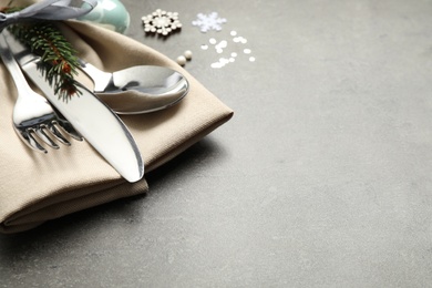 Photo of Cutlery set and festive decor on grey table, closeup with space for text. Christmas celebration