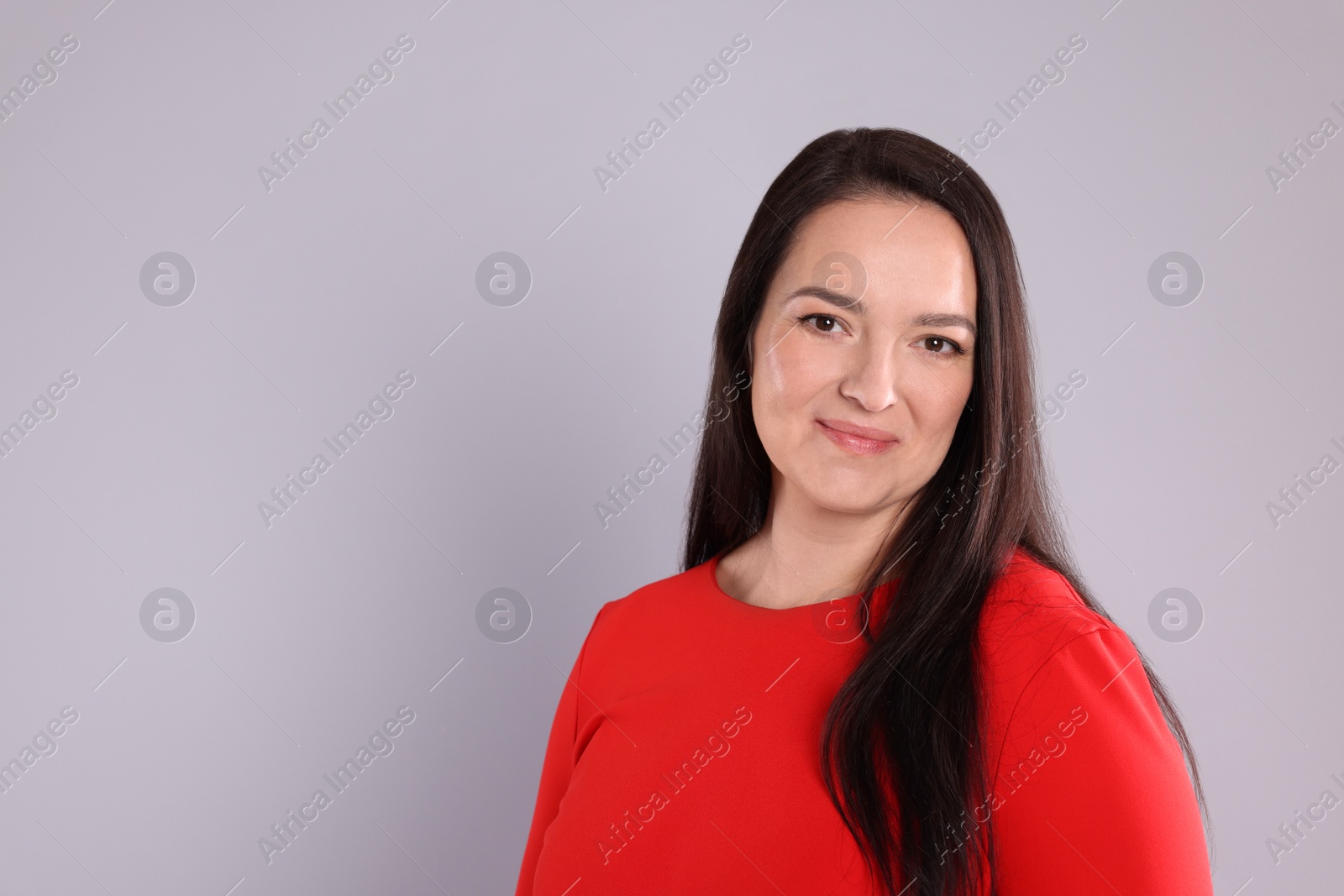 Photo of Beautiful overweight woman in red dress on light grey background. Space for text