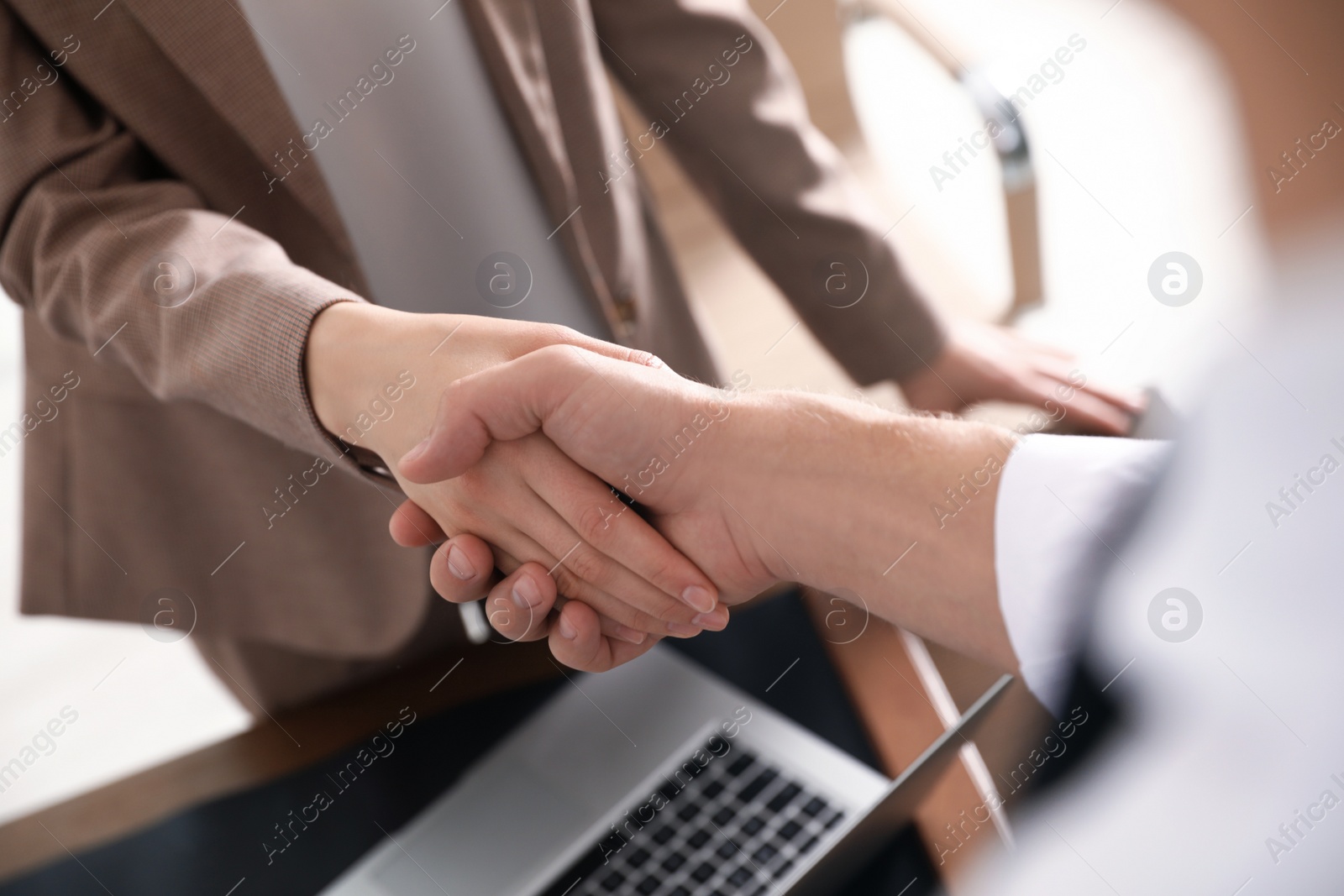 Photo of Business partners shaking hands after meeting, closeup