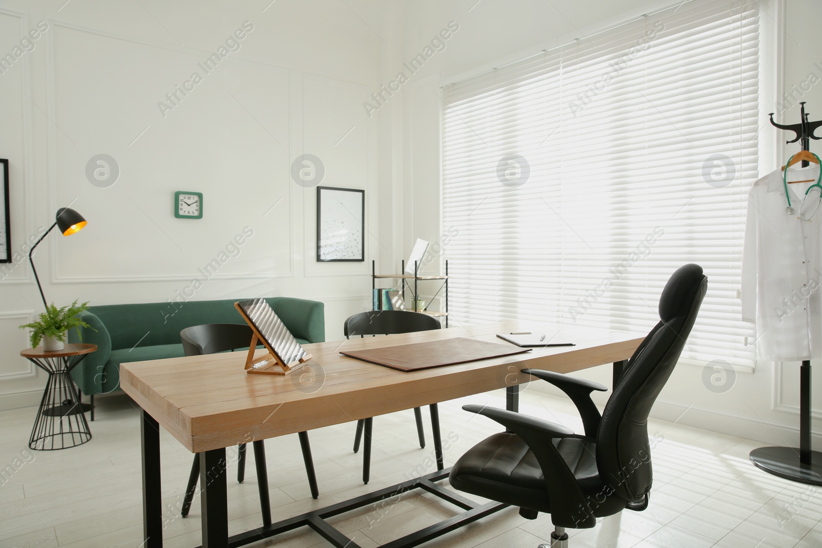 Photo of Modern medical office interior with doctor's workplace and sofa