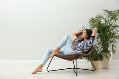 Photo of Young woman relaxing on chair at home, space for text