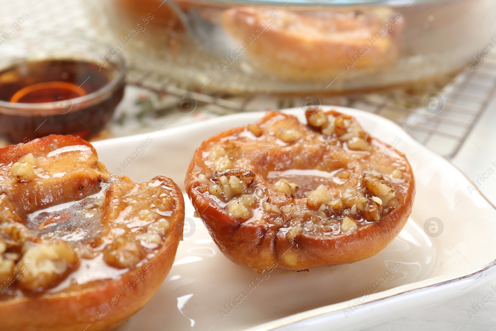 Photo of Delicious quinces baked with honey and walnuts on table, closeup