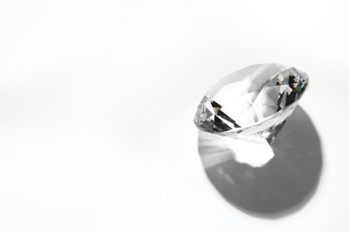 Photo of One beautiful shiny diamond on white background, above view. Space for text