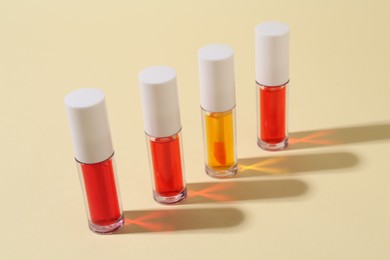 Many bright lip glosses on beige background