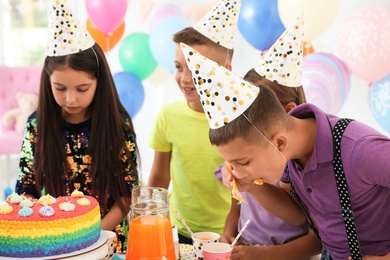 Photo of Happy children eating delicious cake at birthday party indoors