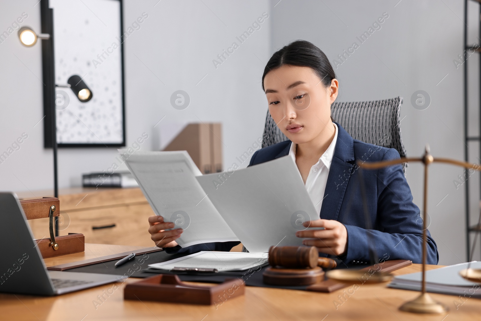 Photo of Notary reading documents at table in office