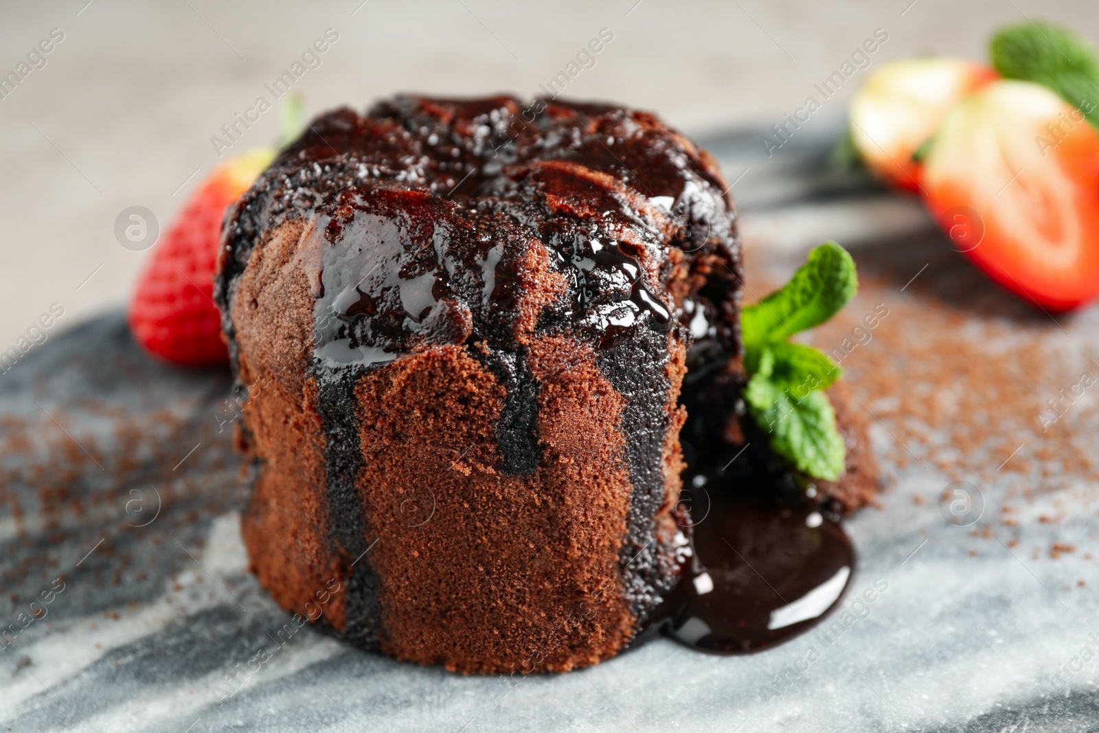 Photo of Delicious warm chocolate lava cake on marble board, closeup