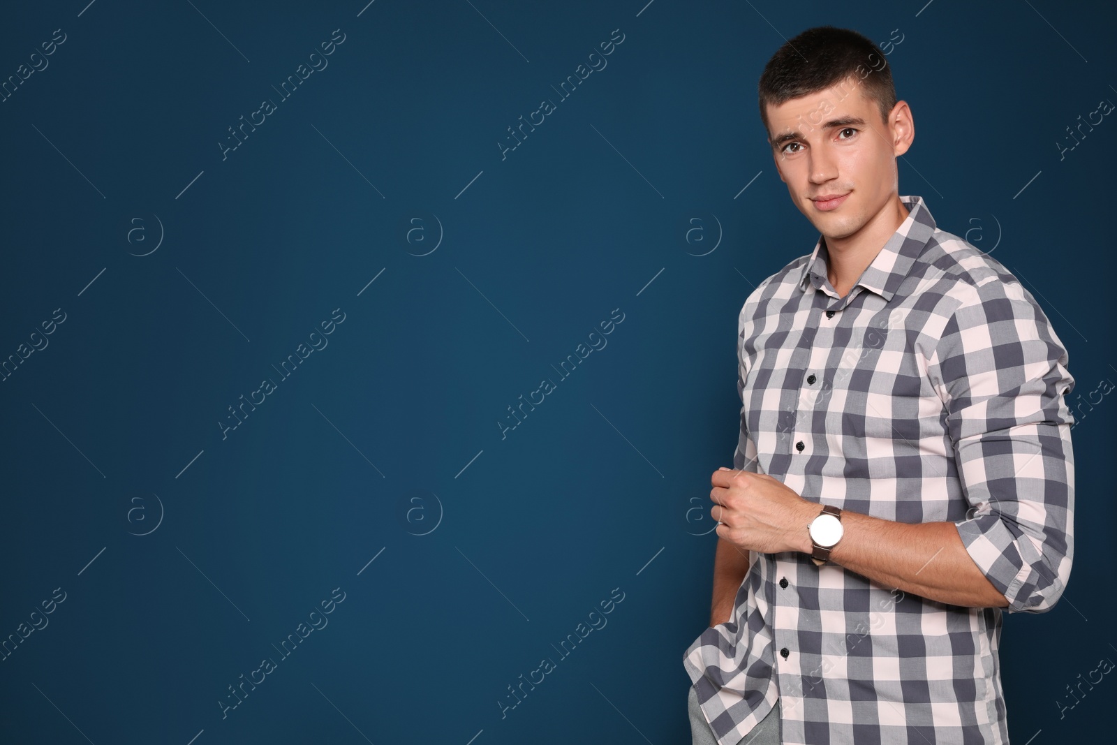 Photo of Portrait of handsome young man on blue background. Space for text