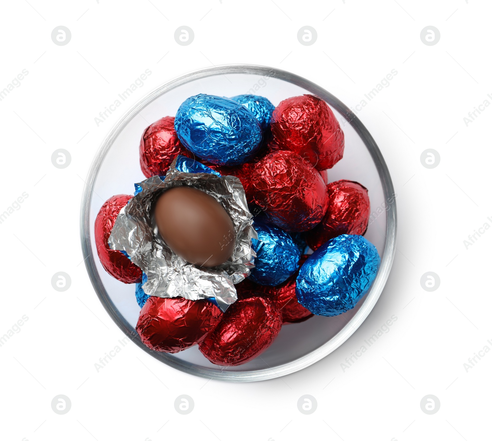 Photo of Glass bowl with chocolate eggs wrapped in colorful foil on white background, top view