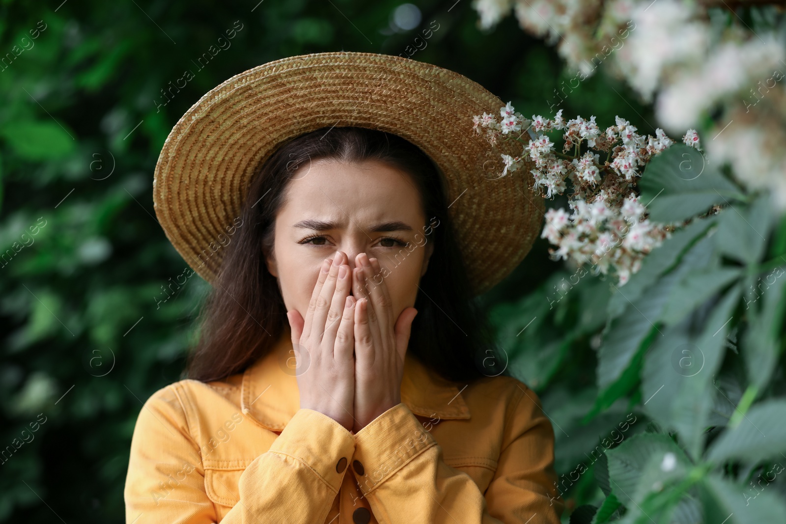 Photo of Woman suffering from seasonal spring allergy near tree in park