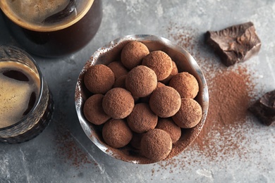 Photo of Bowl with tasty chocolate truffles on grey background, top view