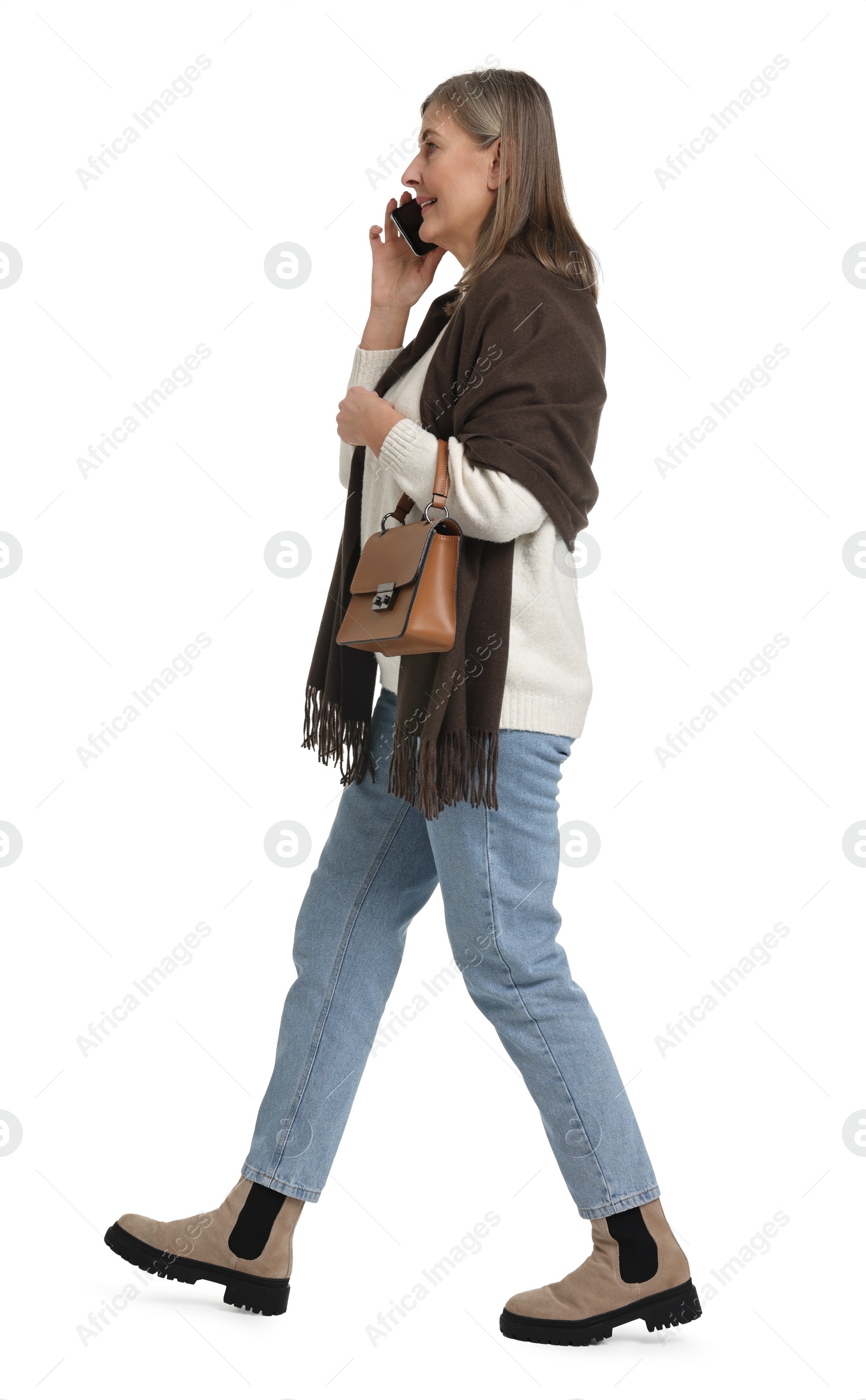 Photo of Senior woman with bag talking on smartphone against white background