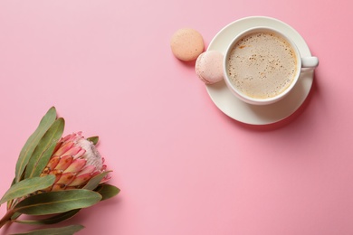 Photo of Creative flat lay composition with tropical flower, cup of coffee and macaroons on color background