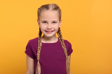 Photo of Portrait of cute girl on orange background