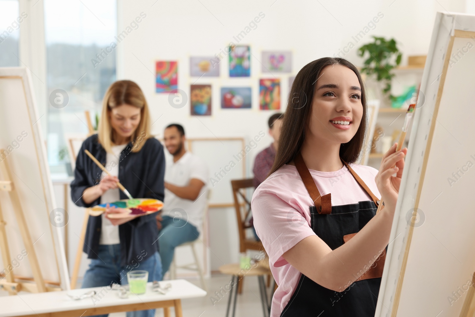 Photo of Group of students attending painting class in studio. Creative hobby