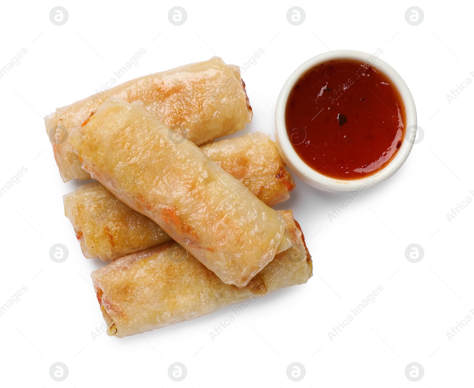 Photo of Tasty fried spring rolls and sauce isolated on white, top view