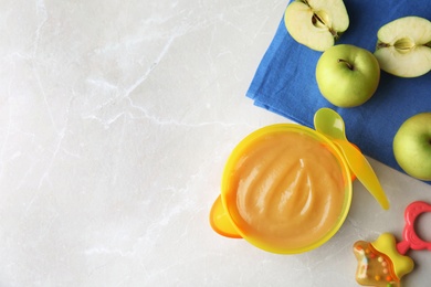 Flat lay composition with bowl of healthy baby food and space for text on light background