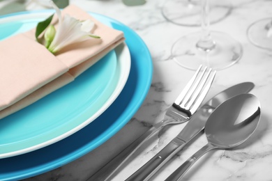 Beautiful table setting with cutlery, napkin and plates on marble background, closeup