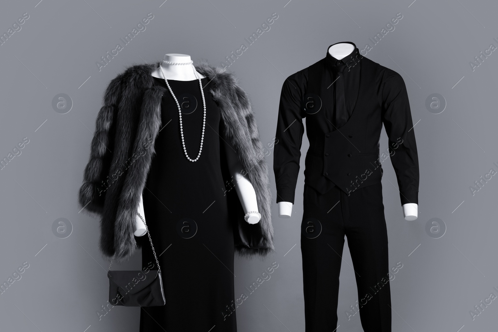 Photo of Male and female mannequins dressed in elegant outfits on grey background