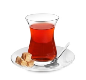 Photo of Glass of traditional Turkish tea with sugar cubes and spoon isolated on white