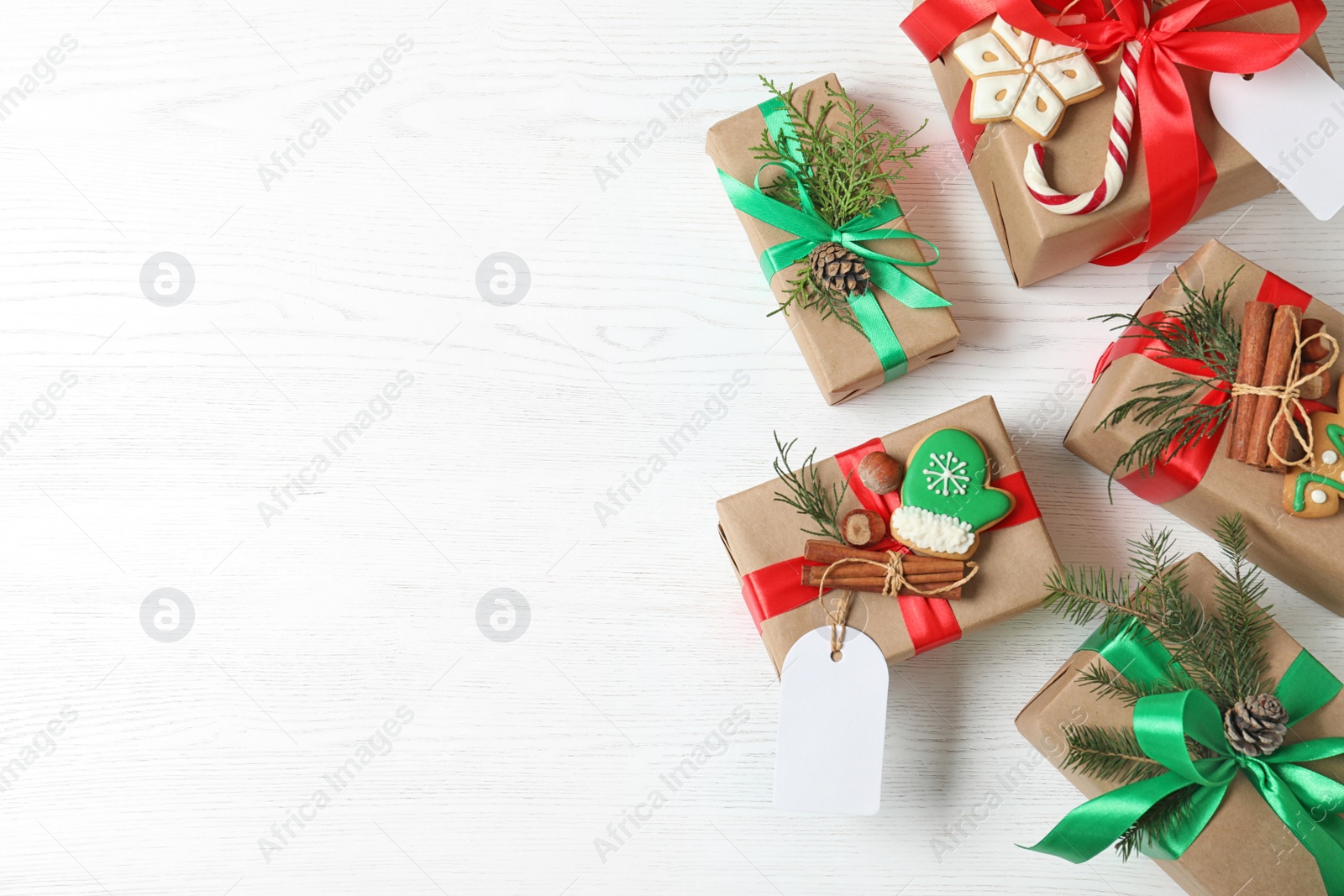 Photo of Flat lay composition with Christmas gift boxes on white wooden background. Space for text