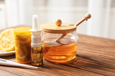 Photo of Natural and medical cold remedies with thermometer on table