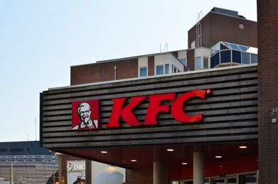 Photo of Hague, Netherlands - May 2, 2022: Exterior of KFC fastfood restaurant with logo on city street