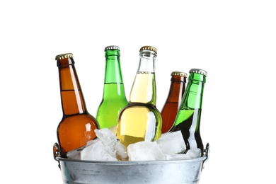 Photo of Bottles with different types of beer and ice in metal bucket on white background