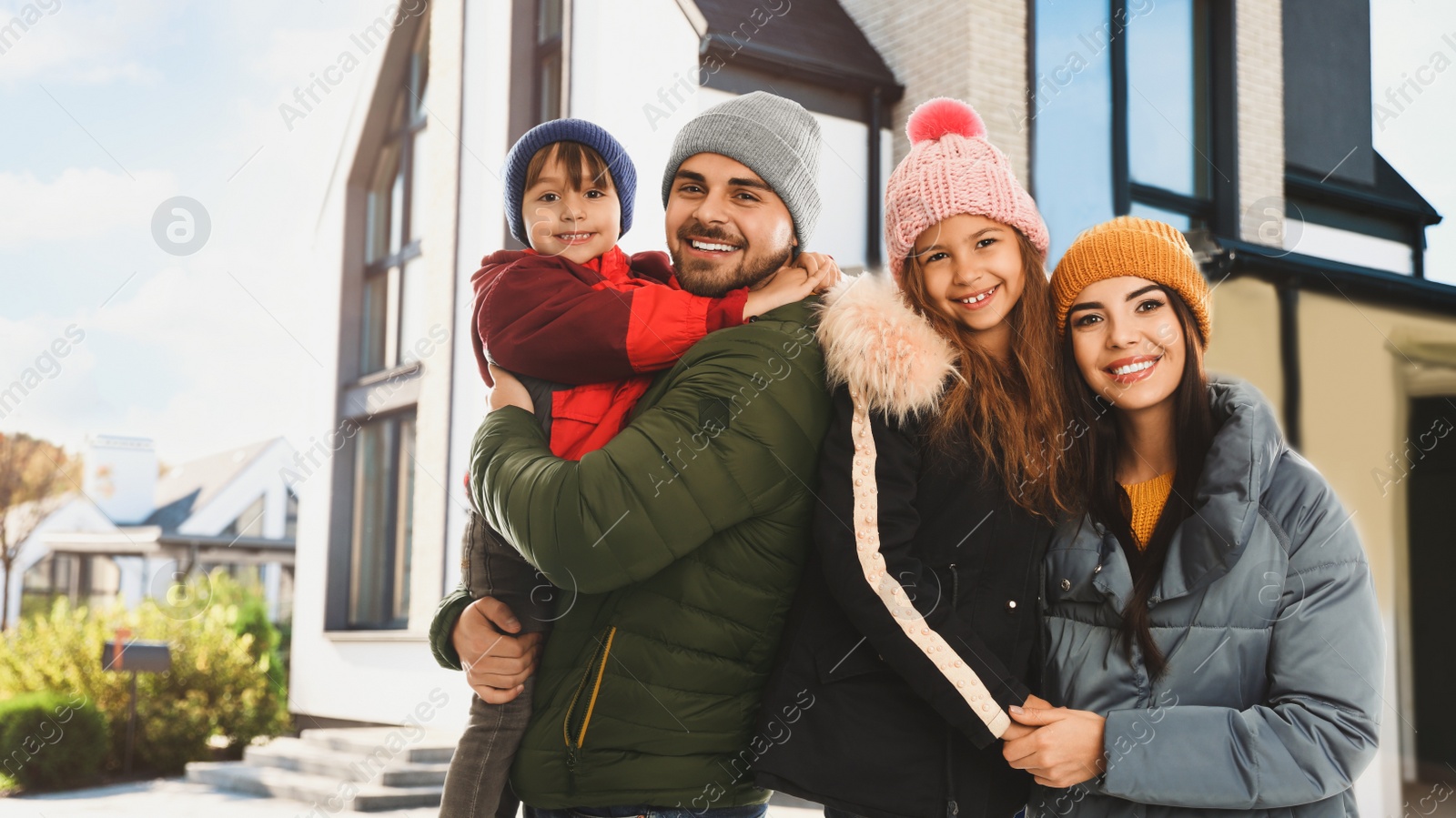 Image of Happy family smiling near their new house