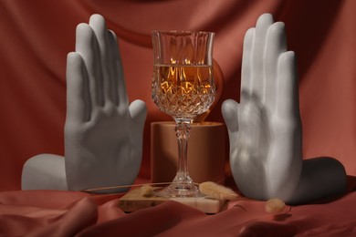 Photo of Stylish composition with glass of alcoholic drink and decor on color fabric