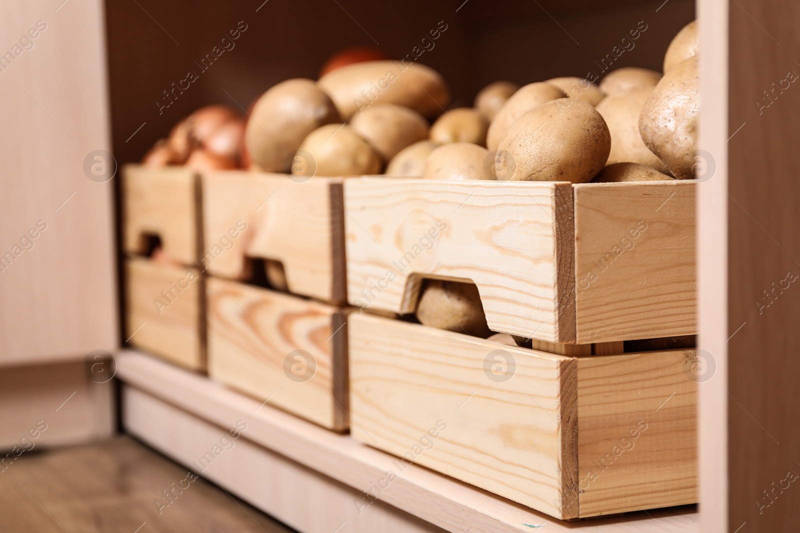 Photo of Crates with potatoes on shelf, closeup. Orderly storage