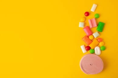 Photo of Many different chewing gums on yellow background, flat lay. Space for text