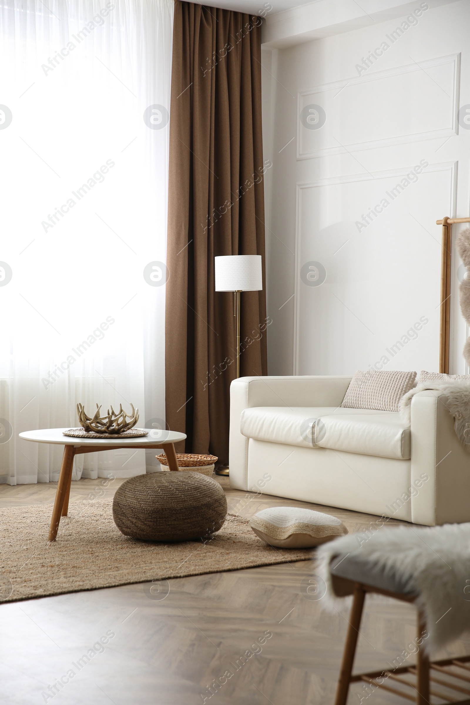 Photo of Table and comfortable sofa in modern room. Interior design