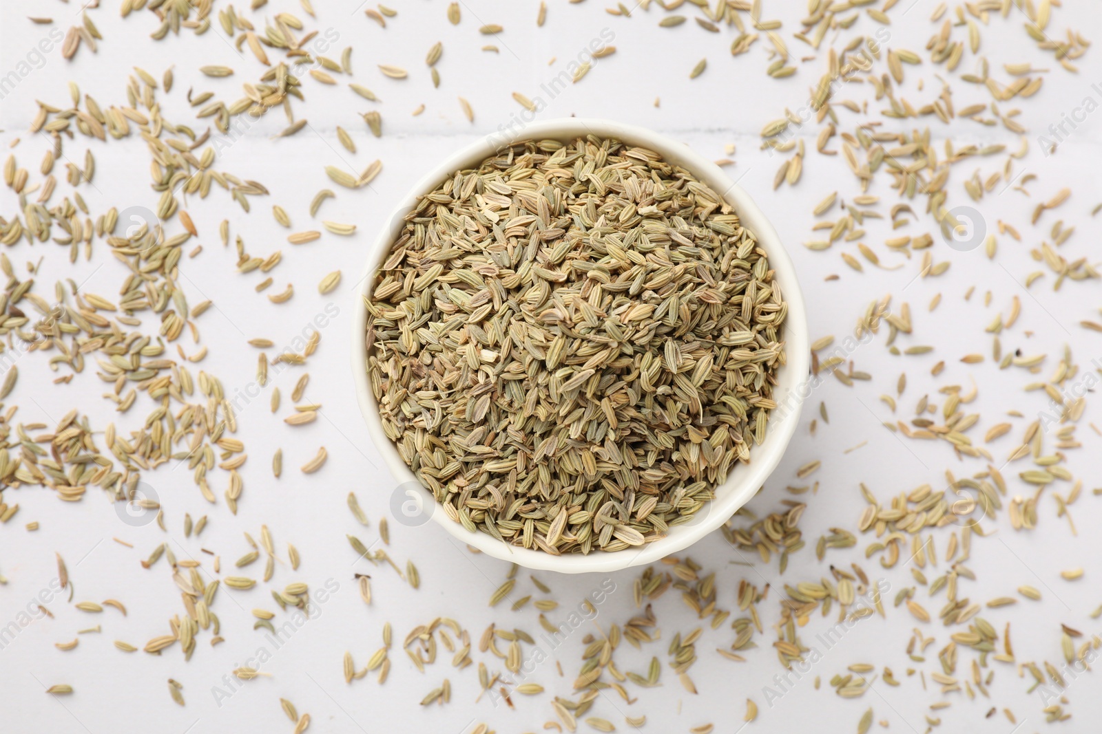 Photo of Bowl with fennel seeds on white table, top view