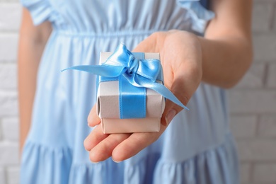 Photo of Woman holding beautiful gift box, closeup