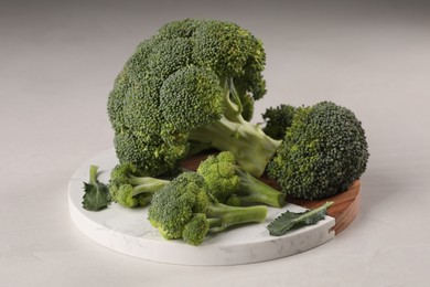 Tray with fresh raw broccoli on white table