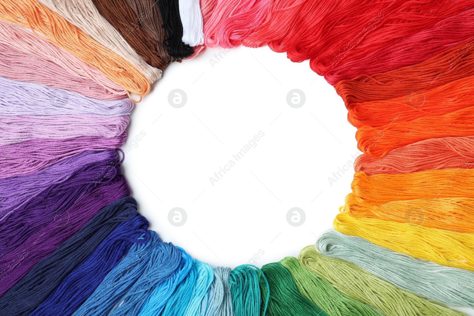 Photo of Frame of colorful embroidery threads on white background, top view